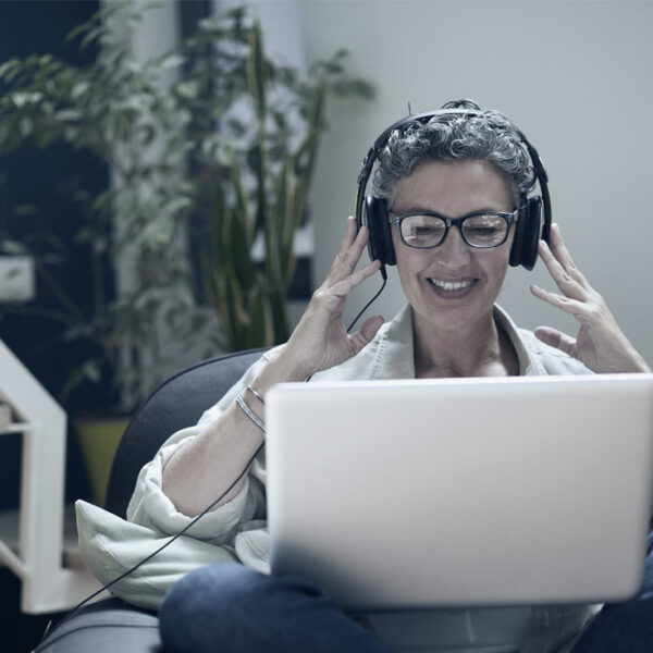 Un coaché est assis sur sa chaise avec son casque en riant et en souriant tout en étant guidé à travers son débriefing EQ-i 2.0.